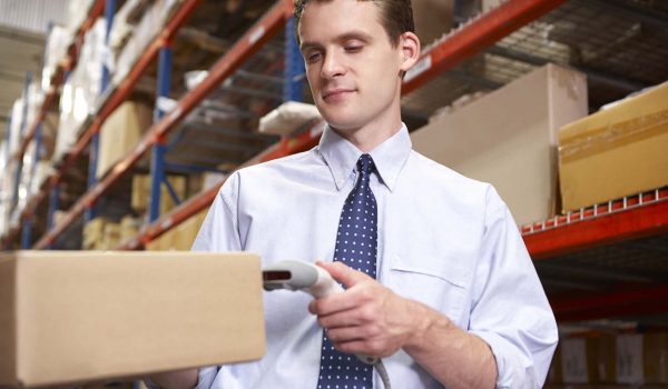Businessman Scanning Package In Warehouse